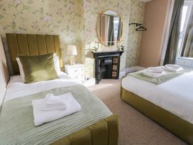 A bedroom with two beds and decorative items at Curzon Heights in Llandudno