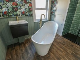 A bathroom with a bathtub and sink at Curzon Heights in Llandudno