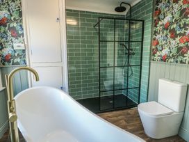 A bathroom with a bathtub, shower, and toilet at Curzon Heights in Llandudno