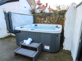 A hot tub with a towel on a stool in an outdoor space at Curzon Heights in Llandudno