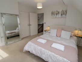 A bedroom with a bed and mirror at Little Acre in Church Lench near Harvington