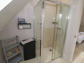 A bathroom with a shower and shelf at Little Acre in Church Lench near Harvington