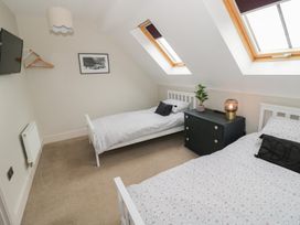 A bedroom with two single beds and a nightstand at Little Acre Church Lench near Harvington