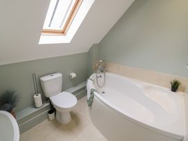 A bathroom with a bathtub and toilet at Little Acre in Church Lench near Harvington