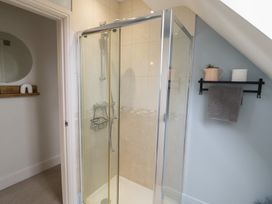 A bathroom with a shower and towel on a shelf at Little Acre in Church Lench near Harvington