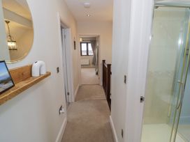 A hallway with a mirror and shelf at Little Acre Church Lench near Harvington