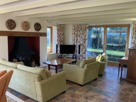 A living room with a fireplace and television at Bryn Isaf in Ystrad Meurig