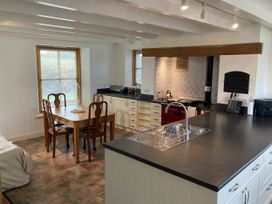 A kitchen with a dining table and chairs at Bryn Isaf in Ystrad Meurig