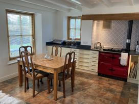 A kitchen with a table and chairs at Bryn Isaf in Ystrad Meurig