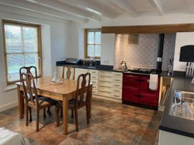 A kitchen with a table and chairs at Bryn Isaf in Ystrad Meurig