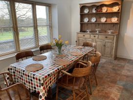 A dining room with a table and chairs at Bryn Isaf in Ystrad Meurig