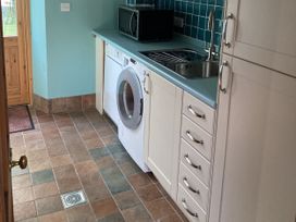 A kitchen with a washing machine and a microwave at Bryn Isaf Ystrad Meurig
