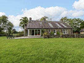 A house with a stone exterior and grass in front at Bryn Isaf in Swyddffynnon near Pontrhydfendigaid