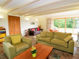 A living room with sofas, a table, and a window at Bryn Isaf near Swyddffynnon near Pontrhydfendigaid