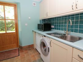 A utility room with a washing machine and microwave at Bryn Isaf in Swyddffynnon near Pontrhydfendigaid