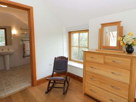 A bedroom with a rocking chair and dresser at Bryn Isaf in Swyddffynnon near Pontrhydfendigaid