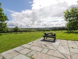 A picnic table on a slate patio with grass in Bryn Isaf near Swyddffynnon near Pontrhydfendigaid