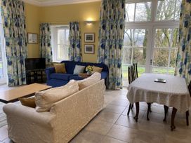 A living room with a sofa and dining table at Ty Cellin in Ystrad Meurig