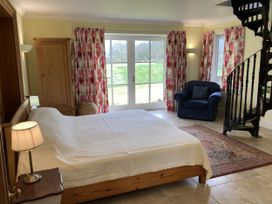 A bedroom with a bed and a chair at Ty Cellin in Ystrad Meurig