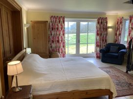 A bedroom with a bed and wardrobe at Ty Cellin in Ystrad Meurig