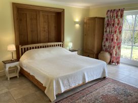 A bedroom with a bed, nightstand, and wardrobe at Ty Cellin in Ystrad Meurig
