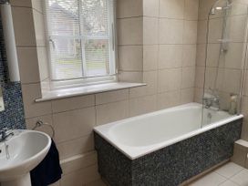 A bathroom with a bathtub and sink at Ty Cellin in Ystrad Meurig