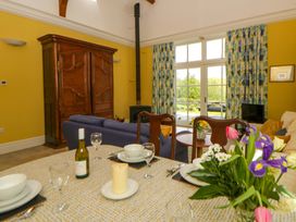 A dining room with a table set and a sofa at Ty Cellin in Swyddffynnon near Pontrhydfendigaid