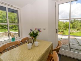 A dining room with a table and flowers at Ty Cellin in Swyddffynnon near Pontrhydfendigaid