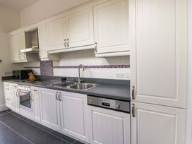 A kitchen with a sink, cooker, and microwave at Ty Cellin in Swyddffynnon near Pontrhydfendigaid