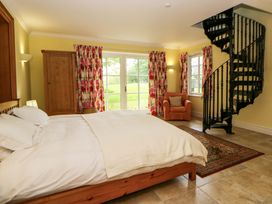 A bedroom with a bed and a spiral staircase at Ty Cellin in Swyddffynnon near Pontrhydfendigaid