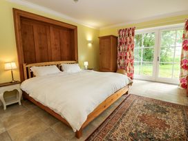 A bedroom with a large bed and wardrobe at Ty Cellin in Swyddffynnon near Pontrhydfendigaid