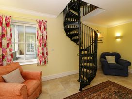 A living room with a spiral staircase and two sofas at Ty Cellin in Swyddffynnon near Pontrhydfendigaid