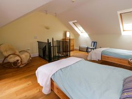 A bedroom with two beds and a rocking chair at Ty Cellin in Swyddffynnon near Pontrhydfendigaid