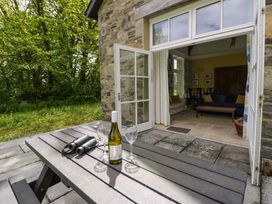 An outdoor patio with a table and wine bottles at Ty Cellin in Swyddffynnon near Pontrhydfendigaid