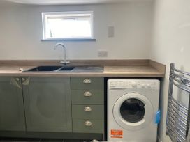 A kitchen with a sink and washing machine at Mys Hedra Farm in Penzance