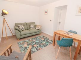 A living room with a sofa, table, and lamp at Mys Hedra Farm in St Buryan