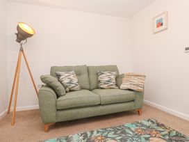 A living room with a sofa and floor lamp at Mys Hedra Farm St Buryan