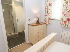 A bedroom with a dresser and a shower room door at Mys Hedra Farm in St Buryan