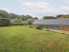 A garden with grass and buildings at Mys Hedra Farm in St Buryan