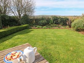 A garden with a table set for tea at Higher Merther Farm Shepherds Hut in Helston