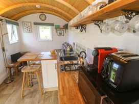 A kitchen with appliances and seating at Higher Merther Farm Shepherds Hut in Helston