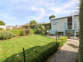 A garden with a shepherd's hut and pathway at Higher Merther Farm Shepherds Hut Helston