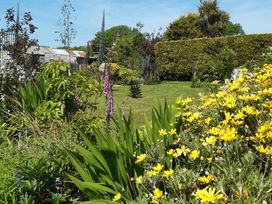 A garden with various flowers and grass at Higher Merther Farm Shepherds Hut in Sithney near Helston