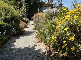 A garden pathway lined with flowers at Higher Merther Farm Shepherds Hut in Sithney near Helston