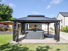A hot tub under a gazebo in the garden at Boathyde Northam