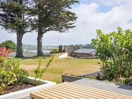 A garden with trees and a view of the water and building at Boathyde Northam