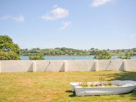 A garden with a boat planter overlooking water at Boathyde in Northam