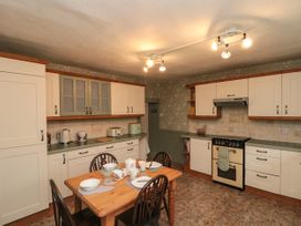 A kitchen with a wooden dining table set for four and white cabinets at Bellmanear Farm Cottage North Grimston near Malton