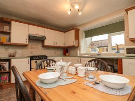 A kitchen with a wooden dining table set for four people at Bellmanear Farm Cottage in North Grimston near Malton