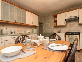 A kitchen with a wooden dining table set for a meal with plates mugs and glasses at Bellmanear Farm Cottage North Grimston near Malton